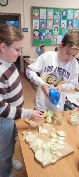 Uczniowie wkładają cebulę 