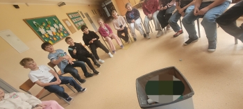 Uczniowie siedzą w kole 