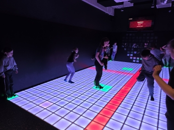 Uczniowie podczas zabawy na interaktywnej planszy