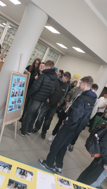 uczniowie czytający informacje na tablicy informacyjnej