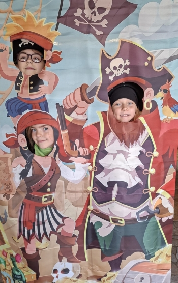 Trzy uśmiechnięte dziewczynki na tle piratów 