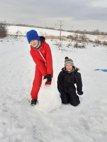 Dwoje chłopców lepiocych kule śnieżną