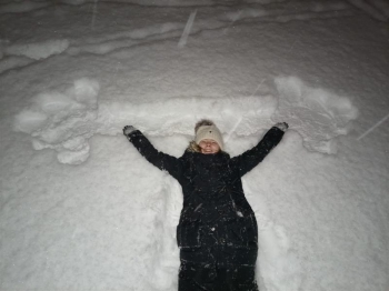 Dziewczynka podnosi sztangę namalowaną na śniegu