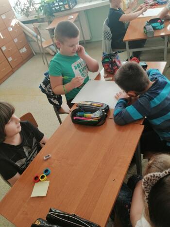 Grupa dzieci pracują z kartami o emocjach 