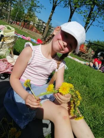 Dziewczynka robiącą wianek z kwiatów 