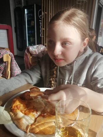 dziewczynka zjada pizzę