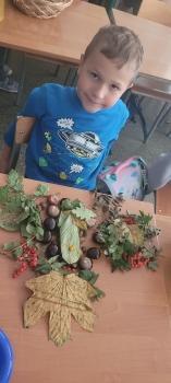 Chłopiec z jesienną mandalą z darów jesieni 