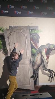 Chłopiec na tle obrazu z dinozaurem 