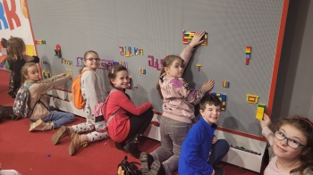 Dzieci budujące z klocków na ścianie 