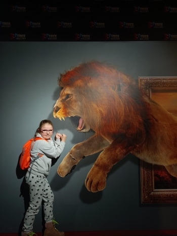 Dziewczynka z obrazem 3d w tle z lwem