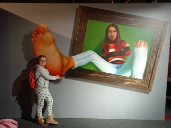 Dziewczynka z obrazem 3d w tle ze stopą 
