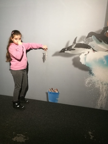 Dziewczynka z obrazem 3d w tle z pingwinami 
