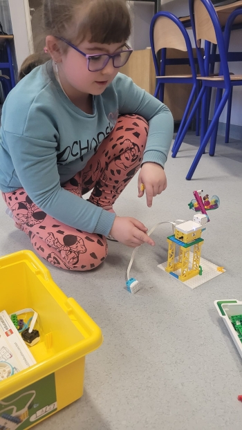 Dziewczynka buduje z klocków lego