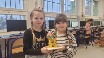 dziewczynki trzymają budowle z klocków Lego