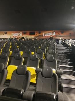 uczniowie siedzą w pustej sali kinowej w ostatnich rzędach