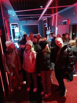uczniowie stoją przed salą kinową w oczekiwaniu na seans