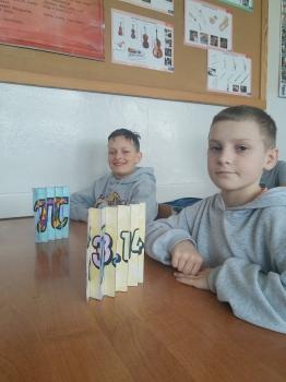 uczniowie z gotowymi pi agamographami gdzie jeden przedstawia symbol liczby pi a drugi wartość tej liczby