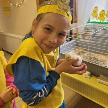 Uśmiechnięta dziewczynka z kurczaczkiem