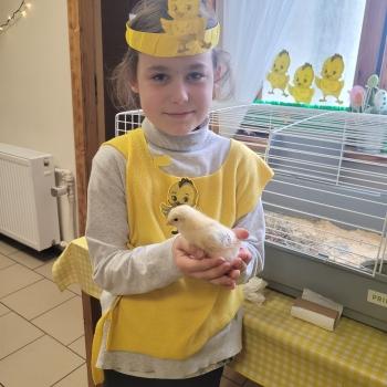 Uśmiechnięta dziewczynka z małym kurczaczkiem