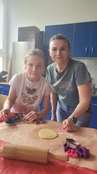 Dziewczynka i nauczycielka przygotowują ciastka 