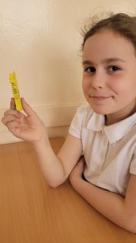 Uśmiechnięta dziewczynka trzyma klatkę z pszczołami 