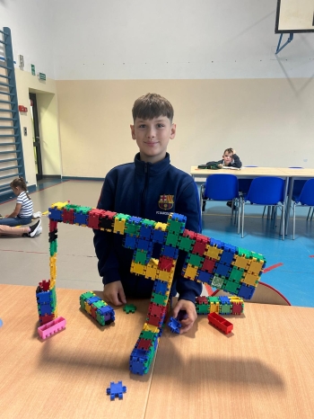 chłopiec z budowlą z klocków typu klick